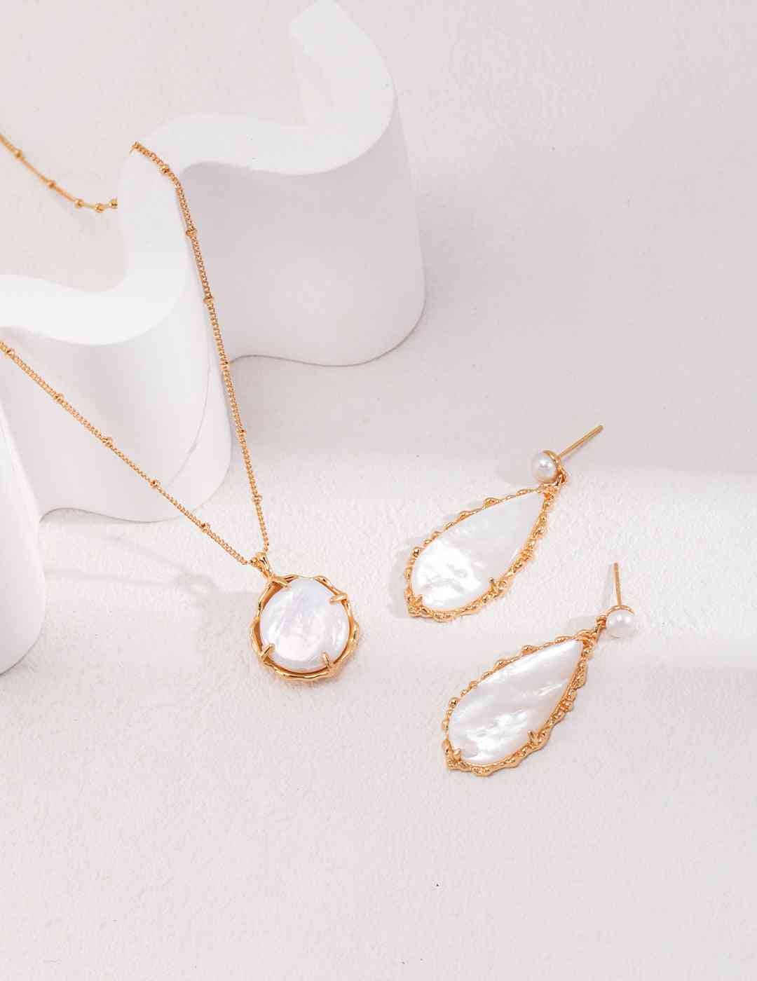 three pieces of jewelry on a white surface