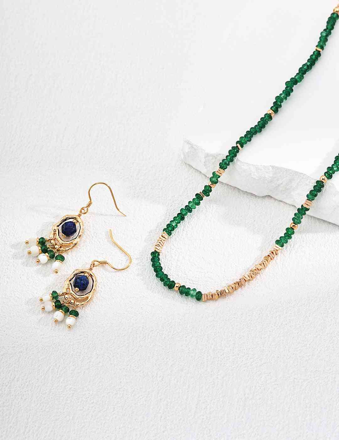 a pair of green beaded necklace and earrings