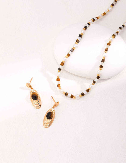 a necklace and earrings on a white surface