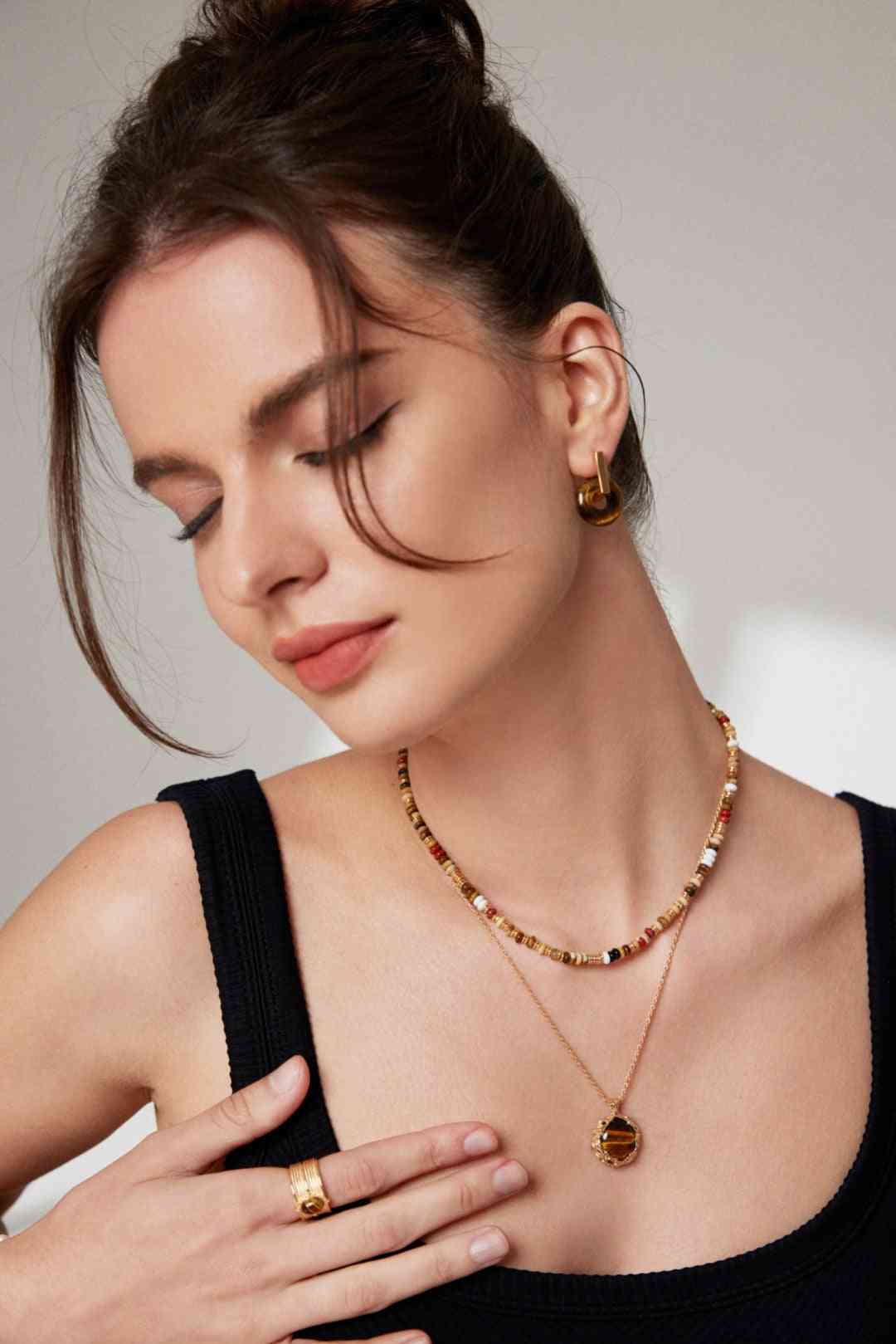 a woman wearing a black top and a gold necklace