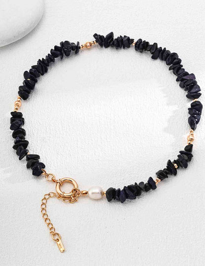 a blue sandstone beaded bracelet with a gold charm