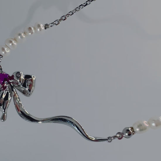 Close-up of spider pendant with purple zircon and pearls