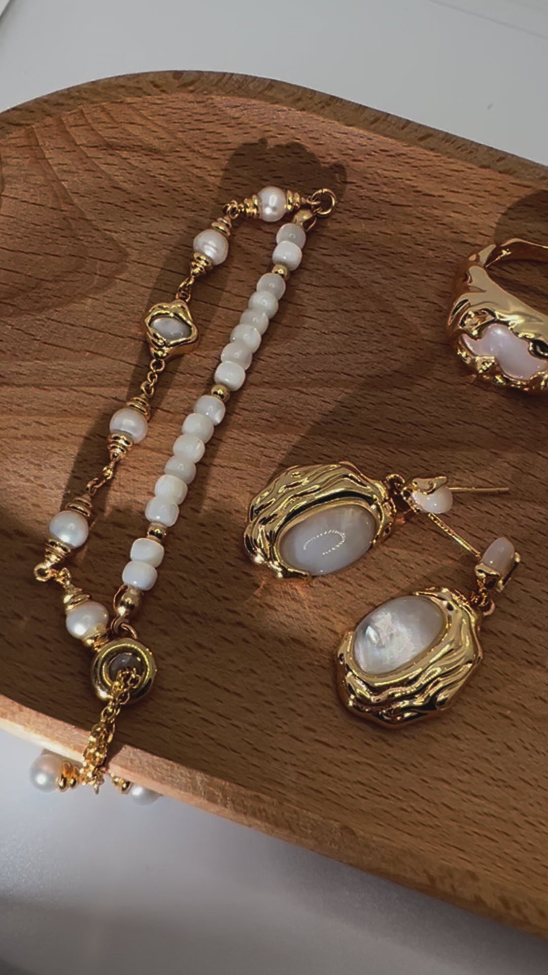 Close-up of seashell bracelet and earrings on wood tray